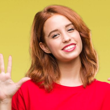 Genç güzel kadın gösterilen ve parmakları ile işaret izole arka plan yüzünden kendinden emin ve mutlu gülümseyerek süre yedi numara.