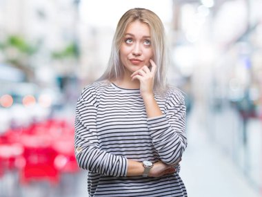 Genç Sarışın kadın elle çene düşünme hakkında soru, dalgın ifade izole arka plan yüzünden. Düşünceli yüzüyle gülümsüyor. Şüphe kavramı.