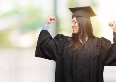 Giyen genç İspanyol kadın kap ve gururlu gülümseyen Tekdüzen gösteren kol kasları mezun oldu. Fitness kavramı.