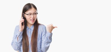 İşaret ve başparmak kadar mutlu yüz gülümseyen tarafı ile gösterilen telefonda konuşan izole arka plan üzerinde Genç Çinli kadın