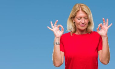 Orta yaş sarışın kadın izole arka plan üzerinde dinlenmek ve gülümseyen gözlerle parmak ile meditasyon jest yapıyor kapalı. Yoga kavramı.