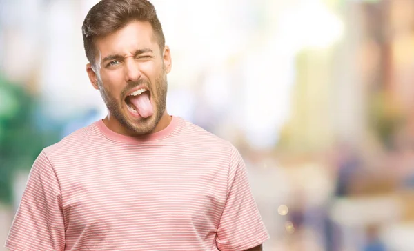 Junger Gutaussehender Mann Über Isoliertem Hintergrund Streckt Die Zunge Glücklich — Stockfoto