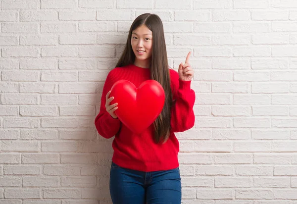 Junge Chinesin Verliebt Über Ziegelmauer Hält Rotes Herz Überrascht Mit — Stockfoto
