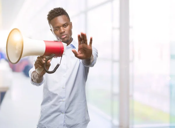 Joven Hombre Afroamericano Sosteniendo Megáfono Con Mano Abierta Haciendo Stop —  Fotos de Stock