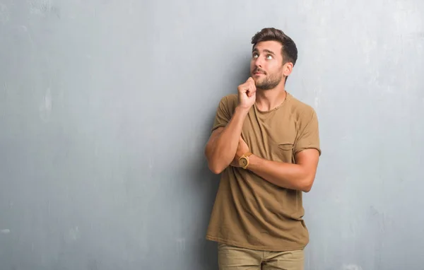 Stilig Ung Man Över Grå Grunge Vägg Med Hand Hakan — Stockfoto