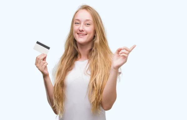 Mulher Adolescente Loira Segurando Cartão Crédito Muito Feliz Apontando Com — Fotografia de Stock