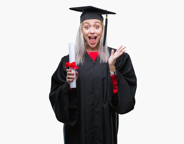 孤立した背景非常に幸せと興奮 勝者式祝う勝利笑顔で叫び 手を上げた上の学位を保持研究科の制服を着て若いブロンドの女性 — ストック写真