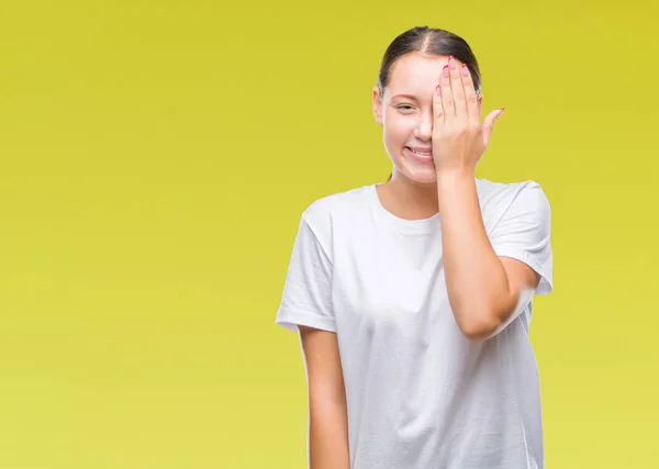 年轻美丽的白人妇女在孤立的背景覆盖一只眼睛与手与自信的微笑在脸上和惊喜的情绪 — 图库照片