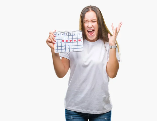 若い白人女性月経周期カレンダーを保持大きな笑顔で叫んで勝利を祝って背景非常に幸せと興奮 受賞式の分離し 手を上げた — ストック写真