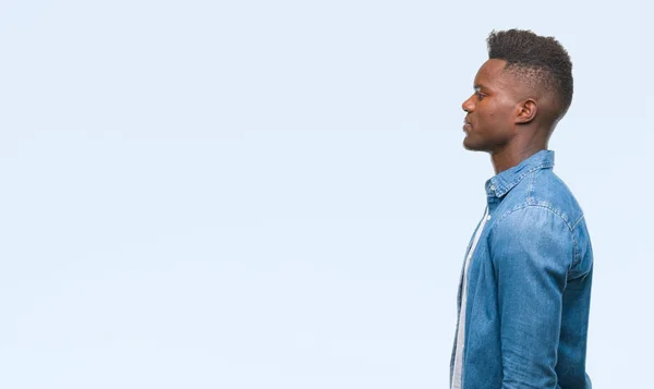 Stock image Young african american man over isolated background looking to side, relax profile pose with natural face with confident smile.