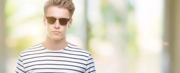 スマートの顔は深刻な思考に自信を持って式の Sunglasess を着ている若いハンサムな金髪男 — ストック写真