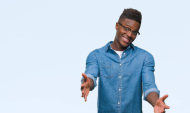 Afrikalı-Amerikalı genç sarılmak için kollarını açarak gülümseyerek kameraya bakarak izole arka plan üzerinde. Neşeli ifade kucaklayan mutluluk.