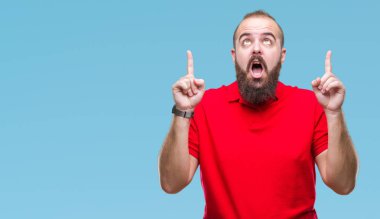 Giyen kırmızı gömlek izole arka plan üzerinden hayran ve yukarıya bakıp parmakları ile işaret şaşırttı ve silah kaldırdı Genç beyaz hipster adam.