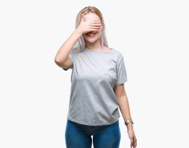 Genç Sarışın kadın gülümsüyor ve gözleri için sürpriz kapsayan yüz el ile gülüyor izole arka plan yüzünden. Kör kavramı.