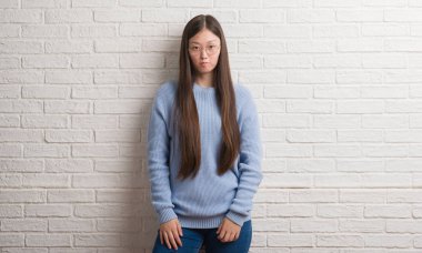 Genç Chinise kadın beyaz tuğla duvarın üzerinden depresif ve kızgın ve korkmuş ağlıyor sıkıntı için endişeleniyorum. Üzgün ifade.