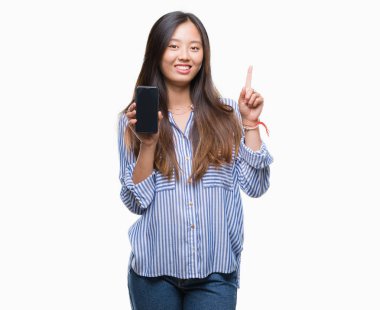 Genç Asyalı kadın gösteren boş ekran smartphone üzerinde arka plan ile bir fikir ya da gülen yüz, bir numara ile parmak işaret soru sürpriz izole