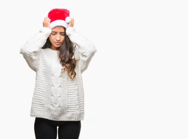 Çünkü çaresiz ve stresli baş ağrısı acı izole arka plan üzerinde Noel şapka giyen genç Arap kadın ağrı ve migren. Ellerini kafasına.