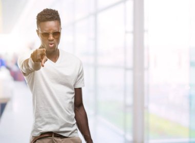 Kamera ve size, el işareti, pozitif ve kendinden emin bir jest ön parmak ile işaret güneş gözlüğü takmış genç Afro-Amerikan adam