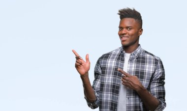 Gülümseyen ve iki elleri ve parmakları ile tarafına işaret kamera bakarak izole arka plan üzerinde genç Afro-Amerikan adam.