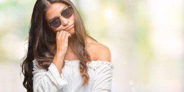 Genç güzel Arap kadın seyir yorgun ve bıkkın ile depresyon sorun Çapraz kollar ile izole arka plan düşünme üzerinde güneş gözlüğü takıyor.