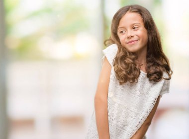 Uzak tarafına gülümseme ile yüzünde, doğal ifade esmer Latin kız. Kendine güvenen gülüyor.