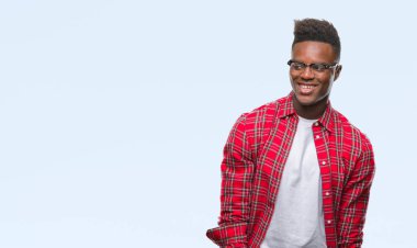 Afrikalı-Amerikalı genç uzak tarafına yüzünde, doğal ifade gülümseme ile seyir izole arka plan üzerinde. Kendine güvenen gülüyor.