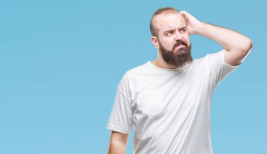 İzole arka plan üzerinde rahat t-shirt giyen genç beyaz hipster adam yanıltır ve soru hakkında merak ediyorum. Şüphe, kafasına el ile düşünme ile belirsiz. Dalgın kavramı.