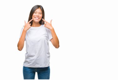 Genç Asyalı kadın kendinden emin gösterilen ve işaret parmakları diş ve ağız ile gülümseyen izole arka plan üzerinde. Sağlık kavramı.