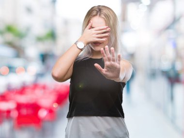 Genç Sarışın kadın izole elleriyle gözlerini kapsayan arka plan ve stop jest ile acı ve korku ifadesi. Utandım ve negatif kavramı.