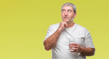 Üst düzey yakışıklı izole arka plan ciddi bir yüz düşünme hakkında soru, çok karışık bir fikir üzerinde bardak su içme