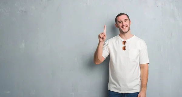 Joven Caucásico Hombre Sobre Gris Grunge Pared Usando Gafas Sol —  Fotos de Stock