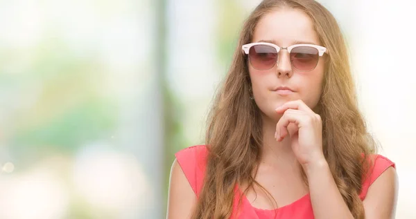 Jovem Loira Vestindo Óculos Sol Rosa Rosto Sério Pensando Questão — Fotografia de Stock