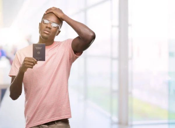 Joven Afroamericano Portador Pasaporte Alemán Acentuado Con Mano Cabeza Conmocionado — Foto de Stock