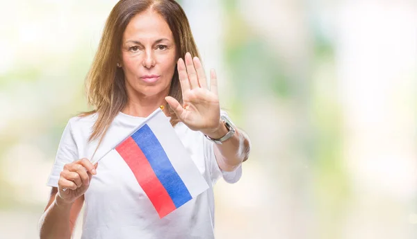 防衛ジェスチャー 深刻な自信を持って式に一時停止の標識を行うオープンの手で隔離された背景にロシアの旗を保持している中年ヒスパニック系女性 — ストック写真