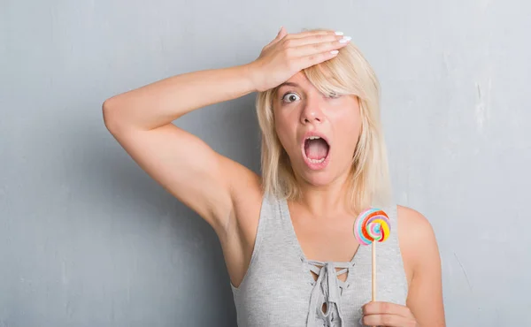 Kaukasische Volwassen Vrouw Grijs Grunge Muur Eten Snoep Lollipop Benadrukt — Stockfoto