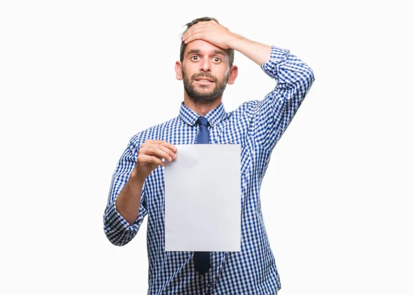 stock image Young handsome man holding blank paper over isolated background stressed with hand on head, shocked with shame and surprise face, angry and frustrated. Fear and upset for mistake.
