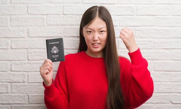 Joven Mujer China Sobre Pared Ladrillo Sosteniendo Pasaporte América Molesto —  Fotos de Stock