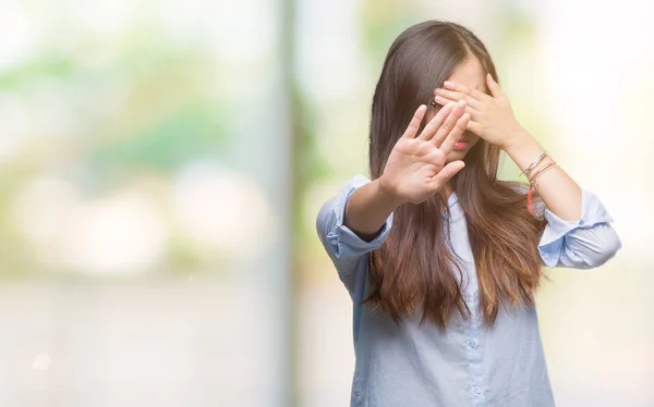 Young asian business woman wearing glasses over isolated background covering eyes with hands and doing stop gesture with sad and fear expression. Embarrassed and negative concept.
