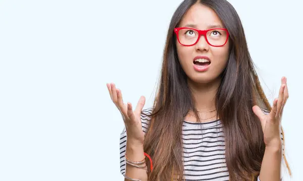 若いアジア女性にメガネをかけて背景クレイジーを分離し 怒って叫んで 叫んで積極的な表現と腕を上げます 欲求不満のコンセプト — ストック写真