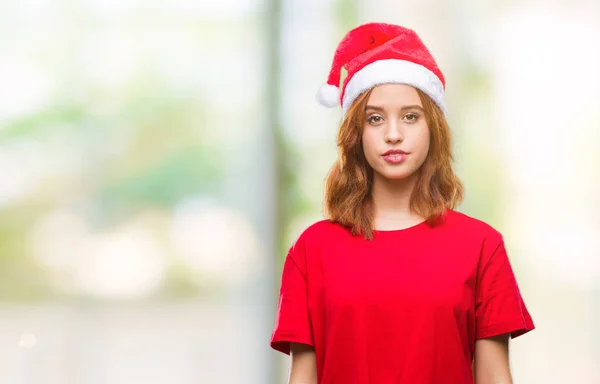 若い美しい女性の顔に幸せとクールな笑顔でクリスマス帽子をかぶっている孤立した背景の上 幸運な人 — ストック写真
