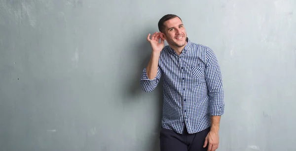 Young Caucasian Man Grey Grunge Wall Smiling Hand Ear Listening — Stock Photo, Image