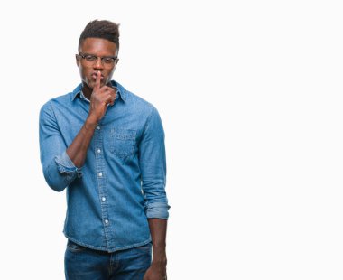 Afrikalı-Amerikalı genç dudaklarında parmak ile sessiz olmanı izole arka plan üzerinde. Sessizlik ve gizli kavramı.