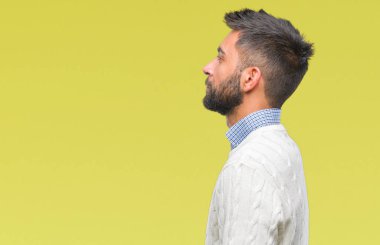 Yetişkin İspanyol adam giyen kış kazak izole arka tarafına, seyir üzerinde dinlenmek doğal yüz emin gülümseme ile pozuyla profili.