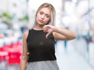 Genç Sarışın kadın yüzünden mutsuz ve kızgın ret gösterilen ve başparmak aşağı hareketi ile negatif seyir izole arka plan. Kötü ifade.