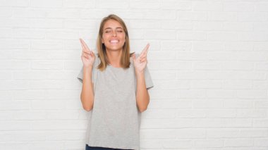 Beyaz tuğla duvar geçiş parmakları umut ve gözler gülümseyen güzel genç kadın kapalı. Şans ve batıl kavramı.