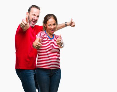 El ile pozitif jest yapıyor onaylama izole arka plan üzerinde aşık orta yaş İspanyol çift başparmak gülümseyen ve başarı için mutlu. Kamera, kazanan jest arıyorsunuz.