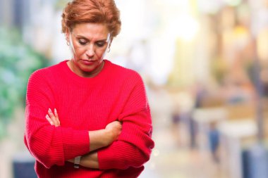 Atrractive üst düzey beyaz Kızıl saçlı kadın giyiyor kış kazak izole arka plan şüpheci ve gergin, ifade ile yüzünde onaylamayan silah geçti. Negatif kişi.