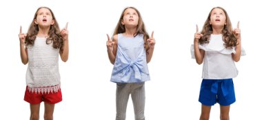 İspanyol Genç çocuk hayret ve yukarıya bakıyor ve parmakları ile işaret ve silah kaldırdı sürpriz izole arka plan üzerinde kolaj.