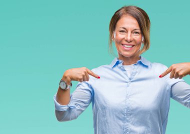 Orta yaş yüzünde gülümseme ile kendinden emin görünüyorsun, kendini gururlu ve mutlu parmakları ile işaret izole arka plan üzerine İspanyol kadın kıdemli.