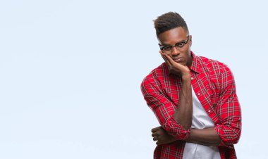 İzole arka plan düşünme seyir üzerinde genç Afro-Amerikan adam yorgun ve sıkılmış çapraz silah depresyon sorunları ile.